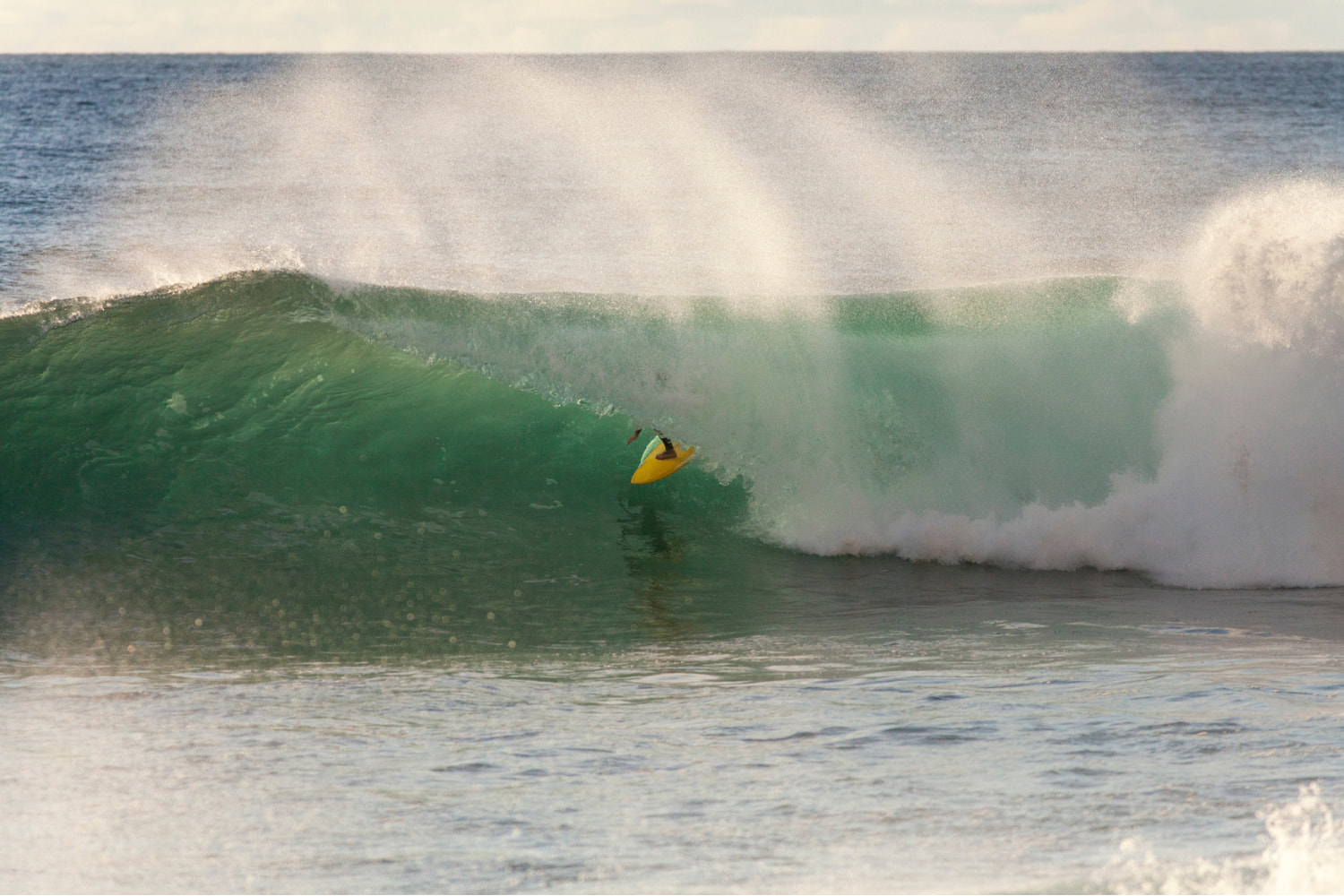 Surfer riding a perfect wave while in a surf guiding session in jardim do mar