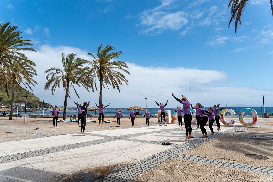 Group of surfers warming up to start riding the waves in the beach the surf guide in madeira gave advice on