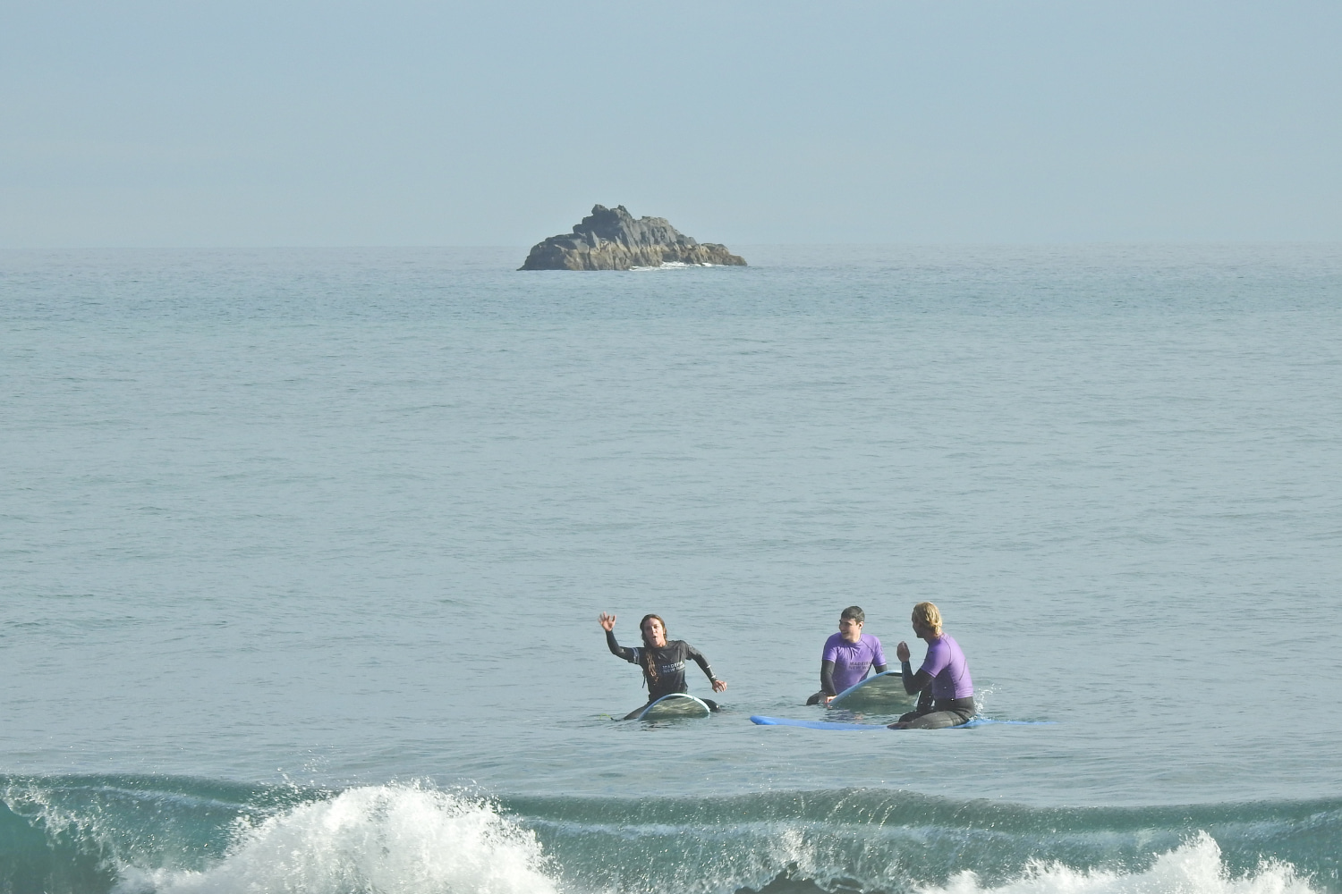 Group of surfers doing a surf lesson in Porto da Cruz with their instructor
