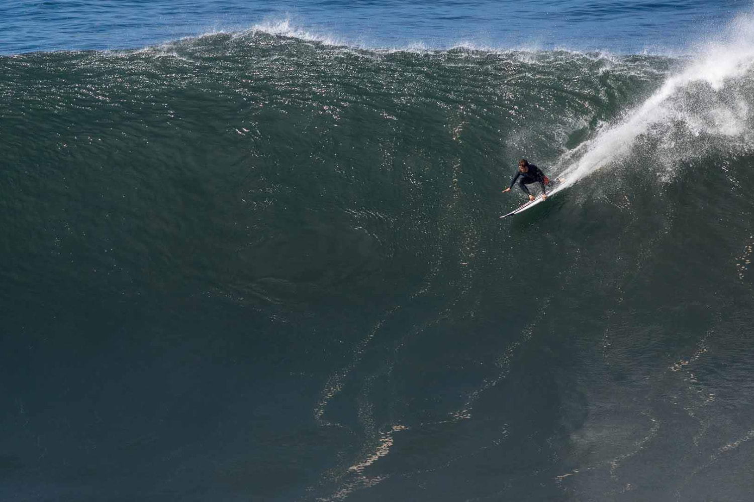 Giant wave with a surfer riding it while in a surf guiding session in jardim do mar